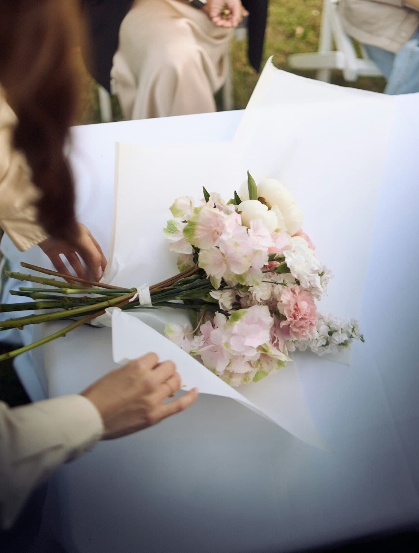 Hands wrapping a bouquet in paper